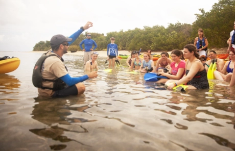 A group of students learns a lesson in the water on a class trip 